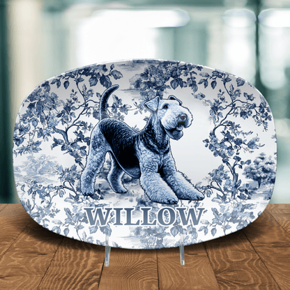 Decorative plate with a toile pattern featuring a personalized name and illustration of an Airdale Terrier on a wooden table. 