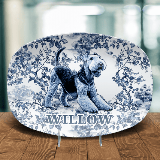 Decorative plate with a toile pattern featuring a personalized name and illustration of an Airdale Terrier on a wooden table. 