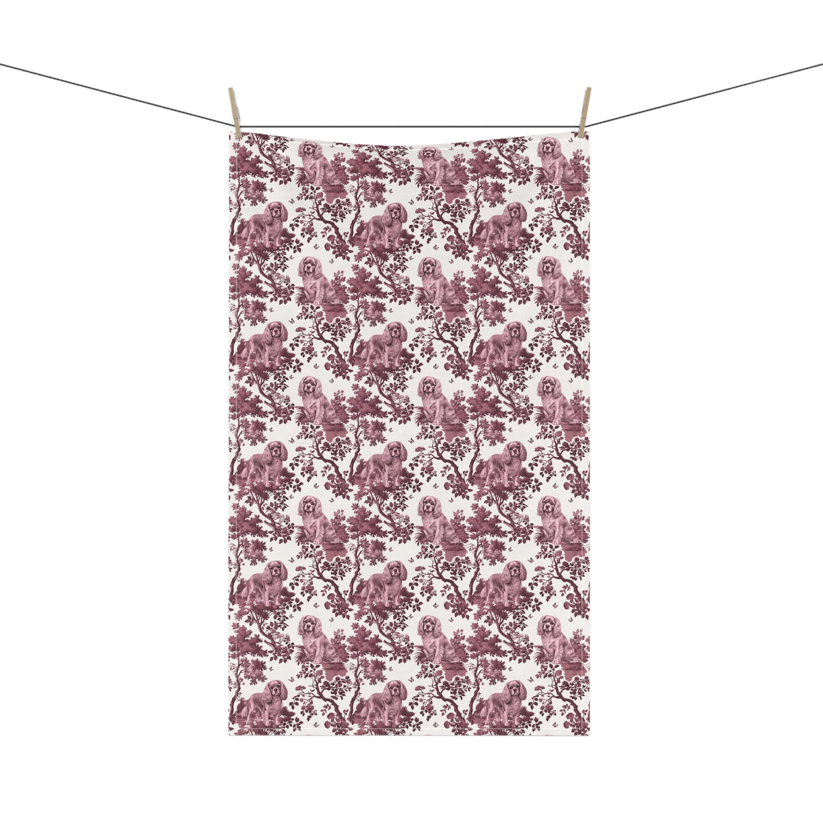 Cavalier King Charles Spaniel Ruby Tea Towel with cranberry toile design, hanging from a clothesline, showing the full repeating design.