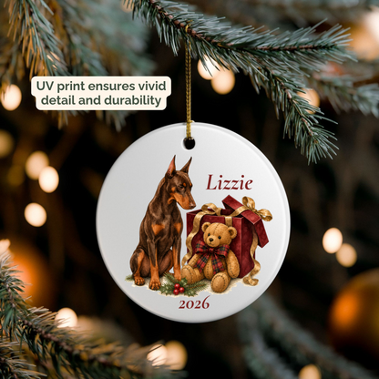 Hand holding a personalized Doberman Pinscher (Red) ceramic ornament beside a Christmas tree
