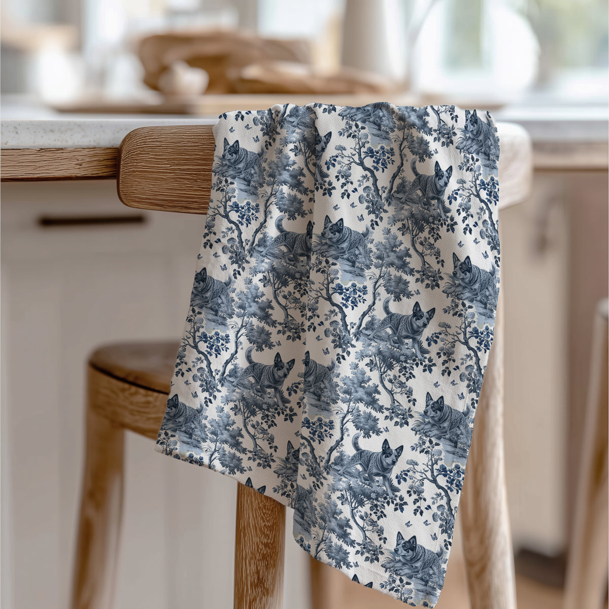 Australian Cattle Dog Blue Tea Towel with blue toile design, draped over a wooden chair in a kitchen.