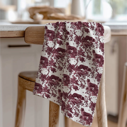 Border Collie Tea Towel with cranberry toile design, draped over a wooden chair in a kitchen.