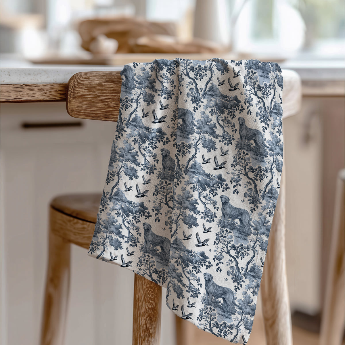 Chesapeake Bay Retriever Tea Towel with blue toile design, draped over a wooden chair in a kitchen.