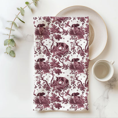 English Springer Spaniel Tea Towel with cranberry toile design, folded beside a plate and cup.