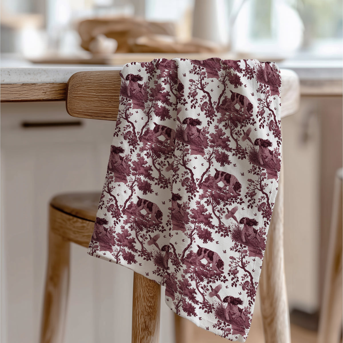 English Springer Spaniel Tea Towel with cranberry toile design, draped over a wooden chair in a kitchen.