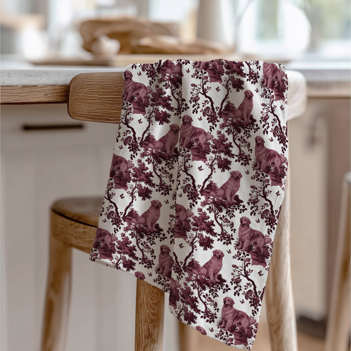 Golden Retriever Tea Towel with cranberry toile design, draped over a wooden chair in a kitchen.