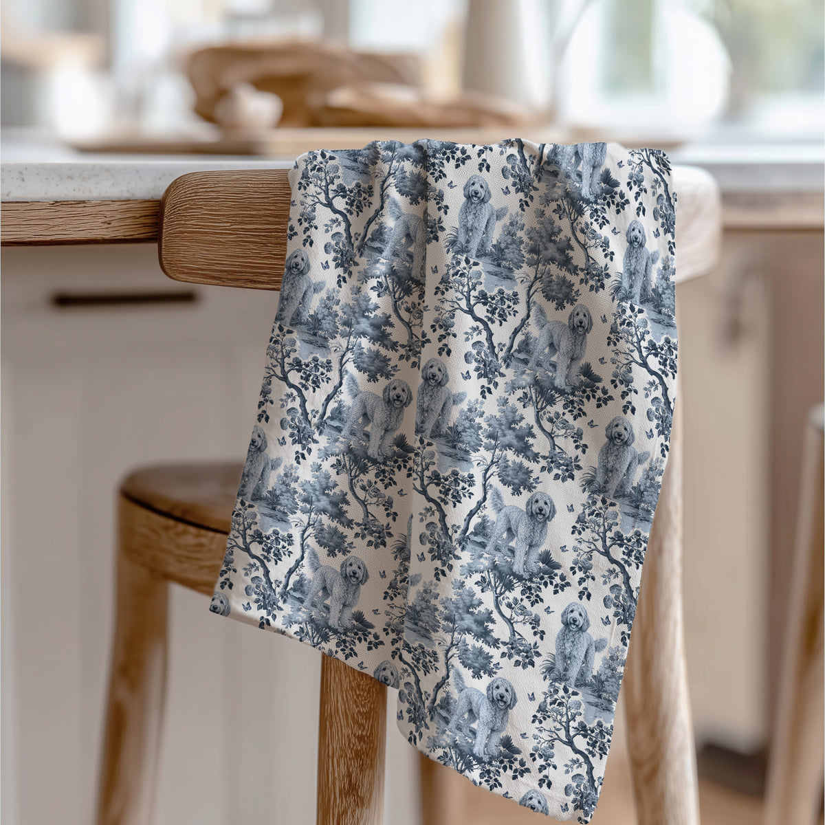 Goldendoodle Tea Towel with blue toile design, draped over a wooden chair in a kitchen.