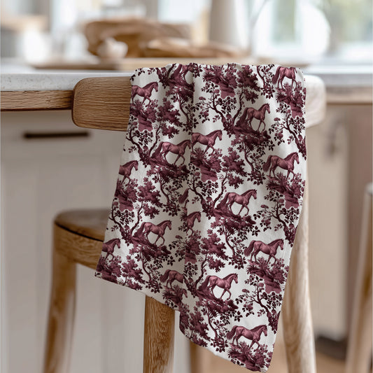 Horse Tea Towel with cranberry toile design, draped over a wooden chair in a kitchen.