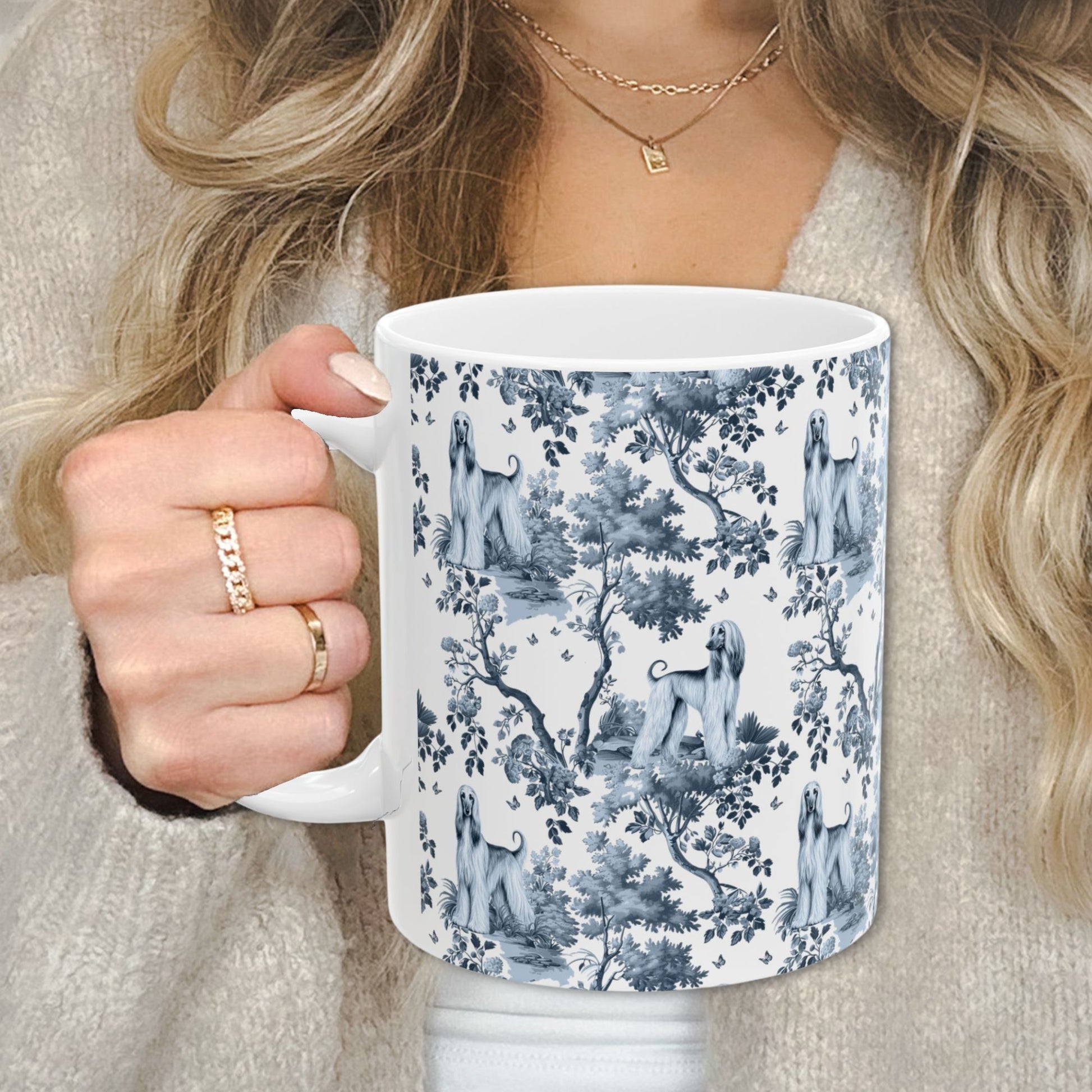 Blue toile Afghan Hound coffee cup against a cozy beige sweater