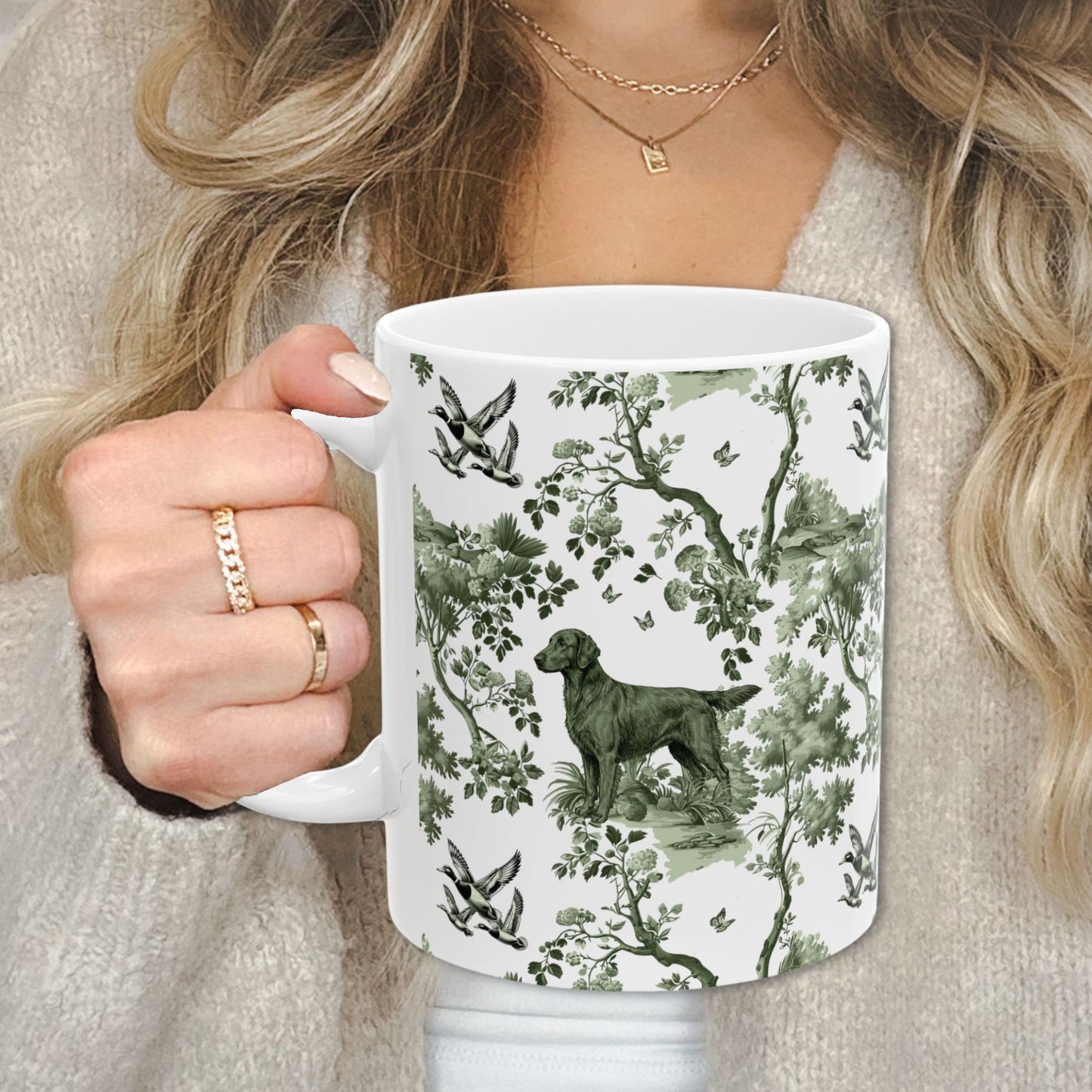 Sage green toile Flat-Coated Retriever coffee cup against a cozy beige sweater