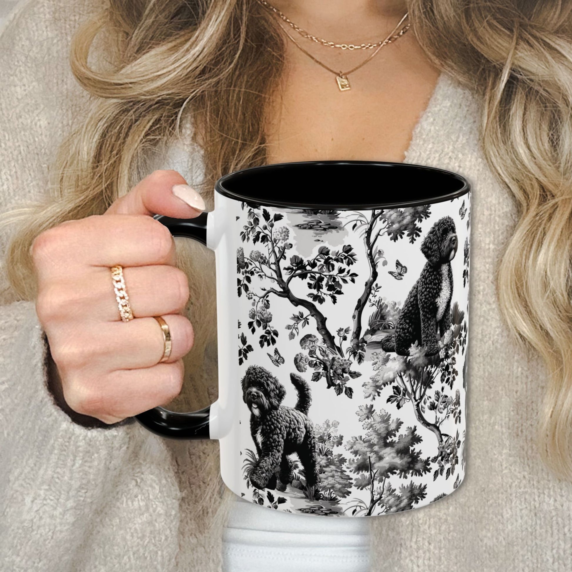 Black toile Portuguese Water Dog coffee cup against a cozy beige sweater