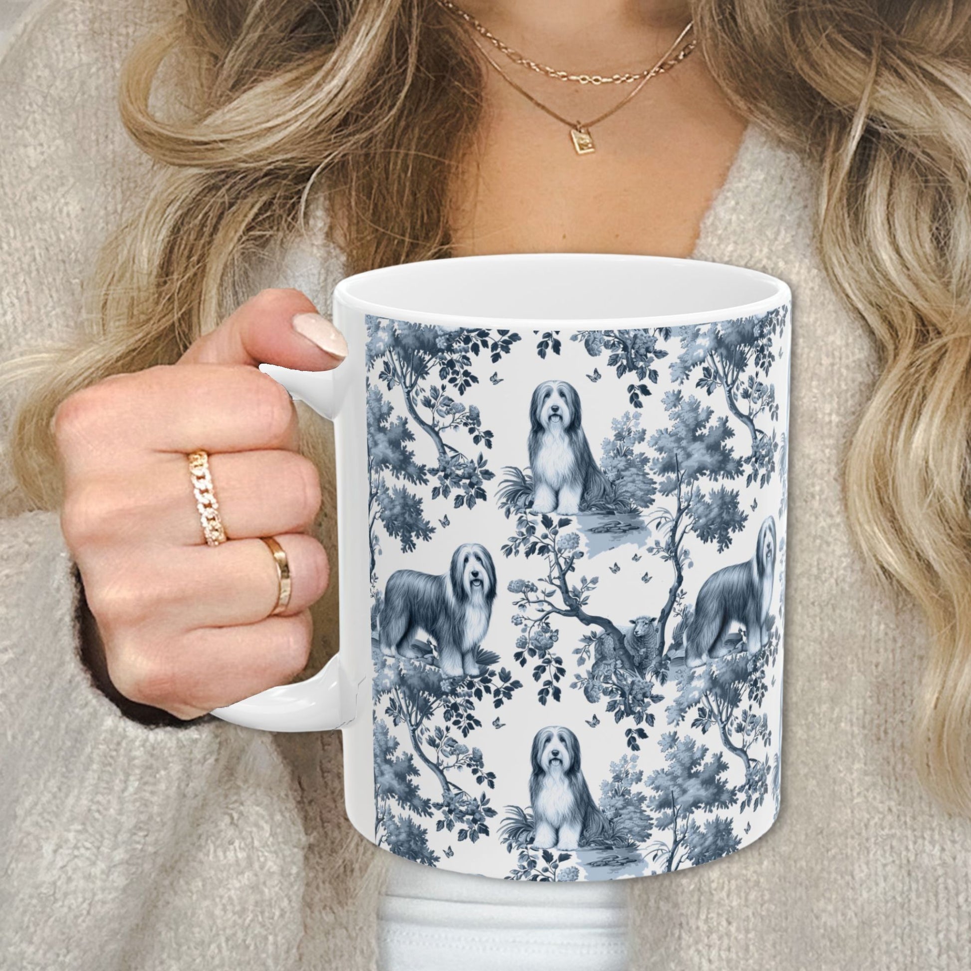 Blue toile Bearded Collie coffee cup against a cozy beige sweater