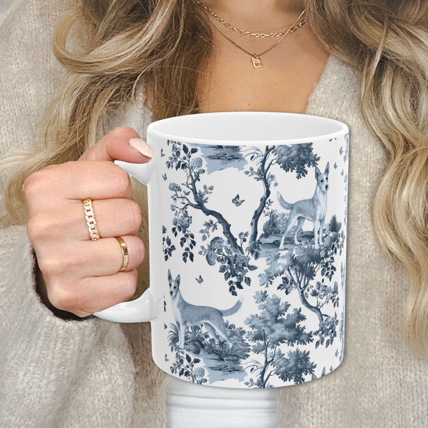 Blue toile Portuguese Podengo coffee cup against a cozy beige sweater