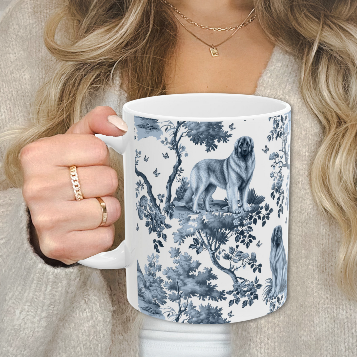 Leonberger blue toile white handle mug held by a person in a beige sweater