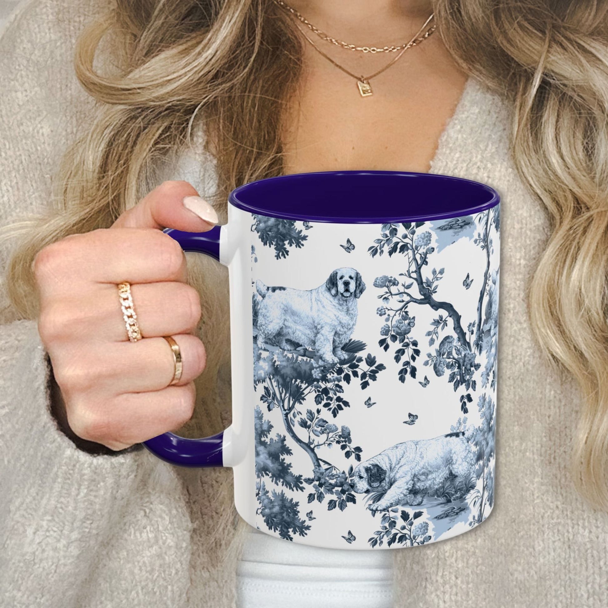 Blue toile Clumber Spaniel coffee cup against a cozy beige sweater
