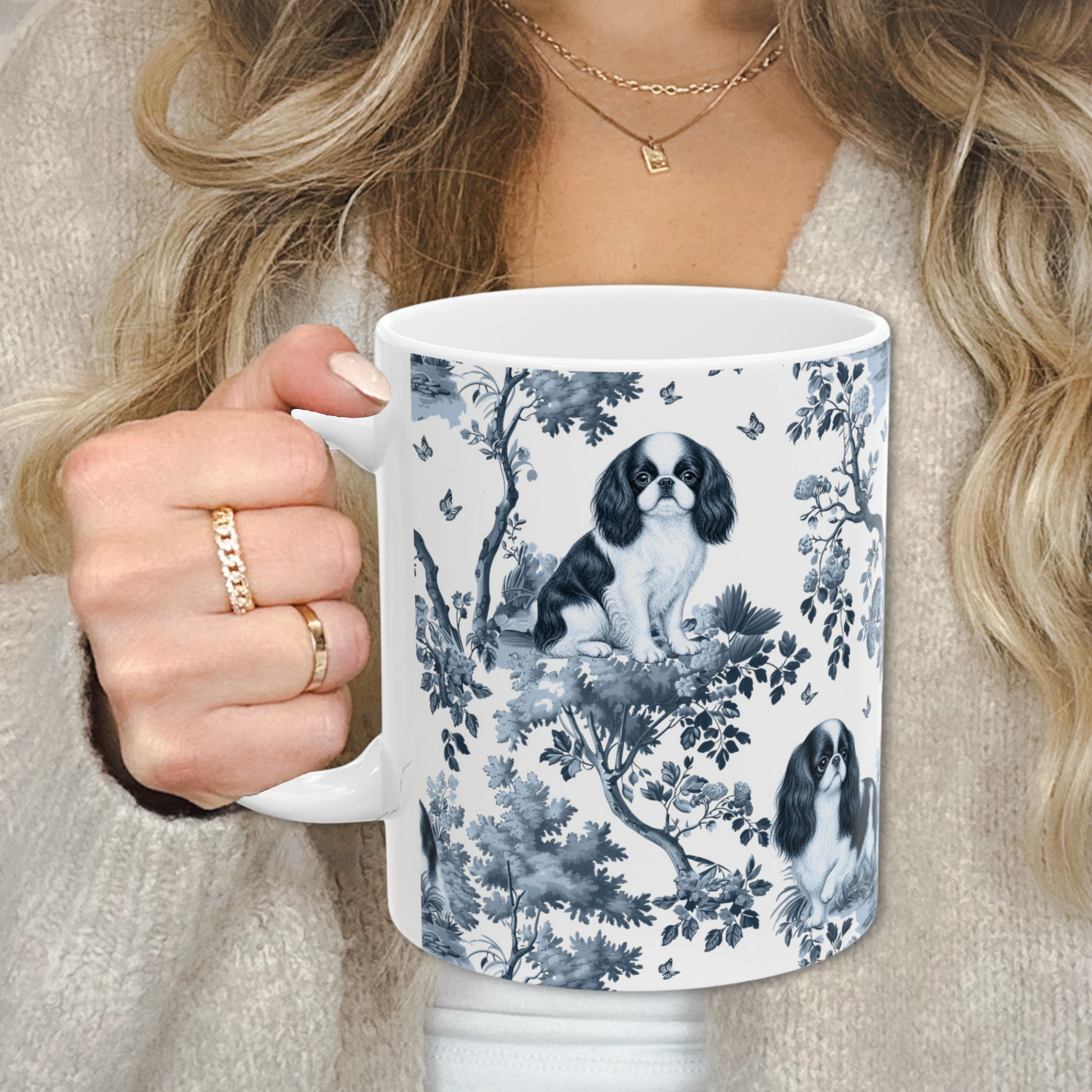 English Toy Spaniel blue toile white handle mug held by a person in a beige sweater