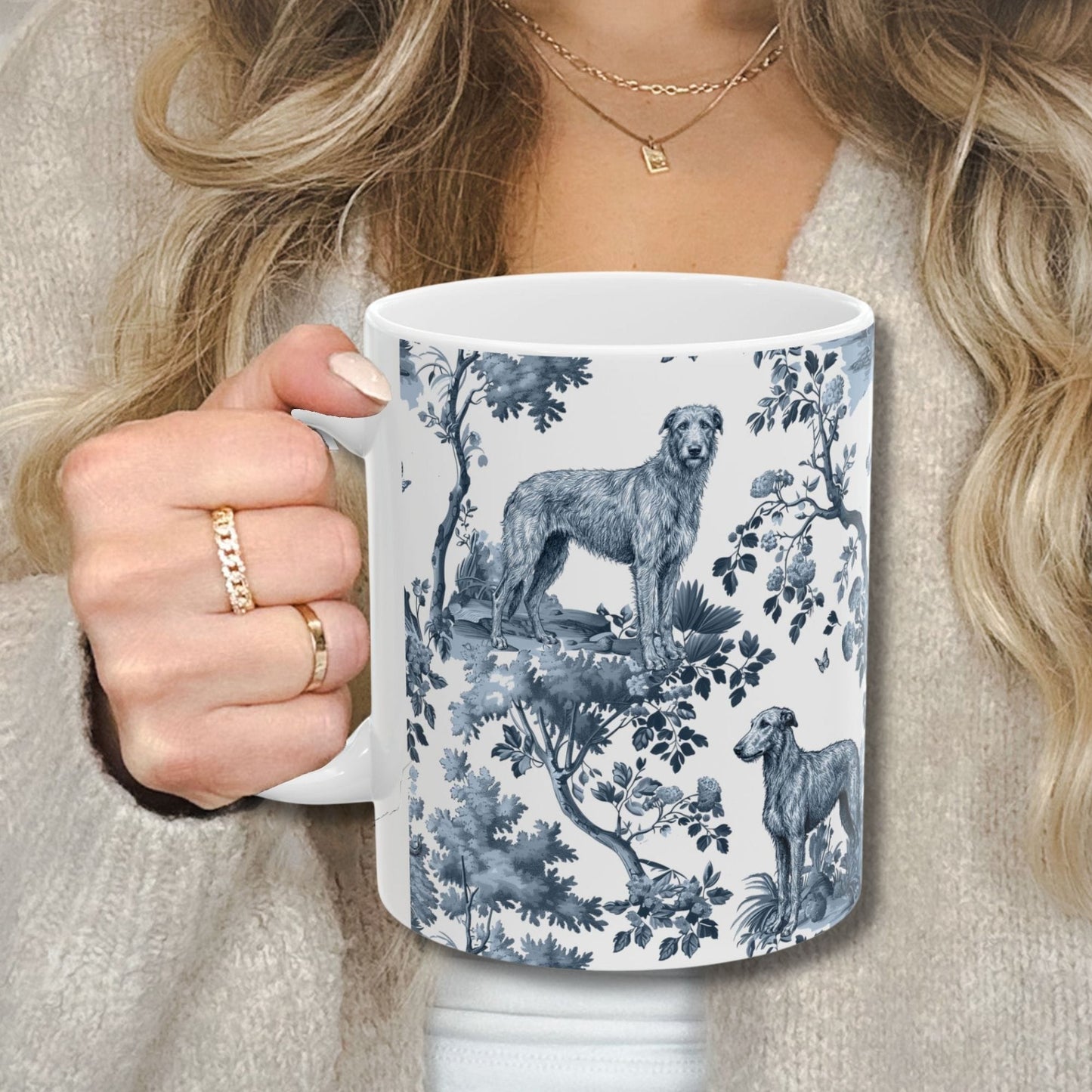 Blue toile Scottish Deerhound coffee cup against a cozy beige sweater