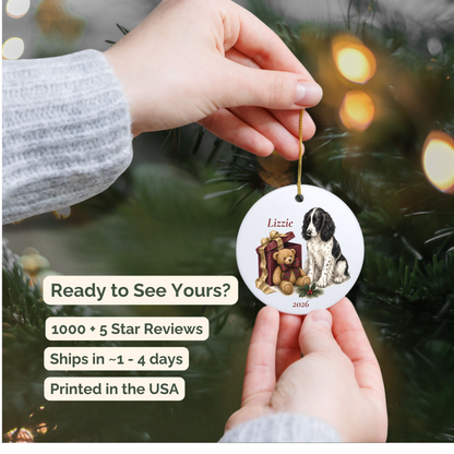 Hand holding a personalized English Springer Spaniel (Black) ceramic ornament beside a Christmas tree