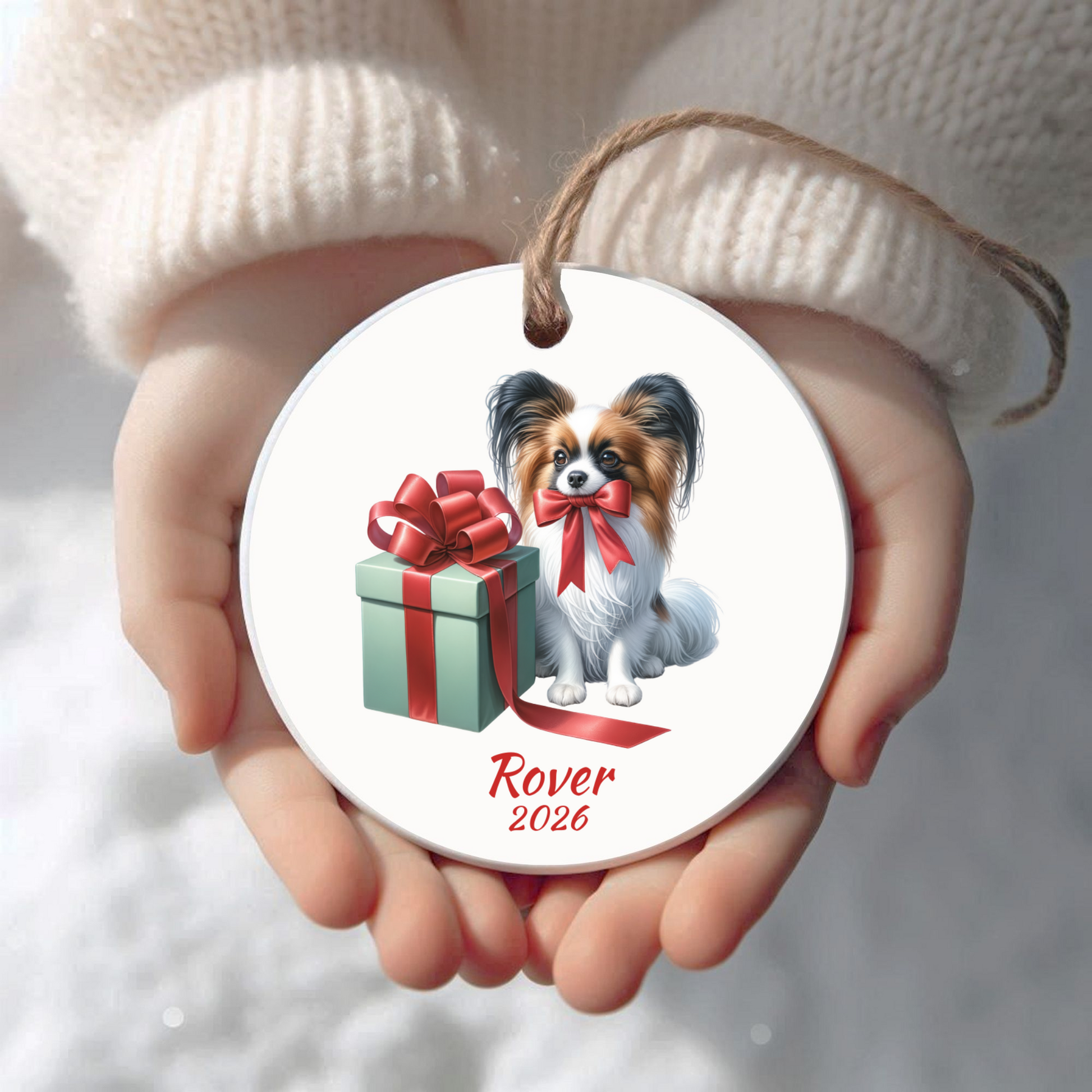 Personalized Papillon Christmas ornament held in cupped hands